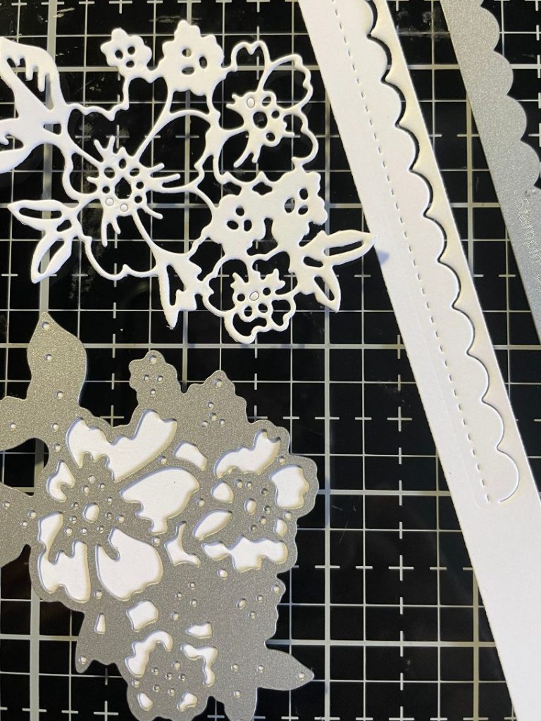 Floral and scallop strip dies cut from white card stock