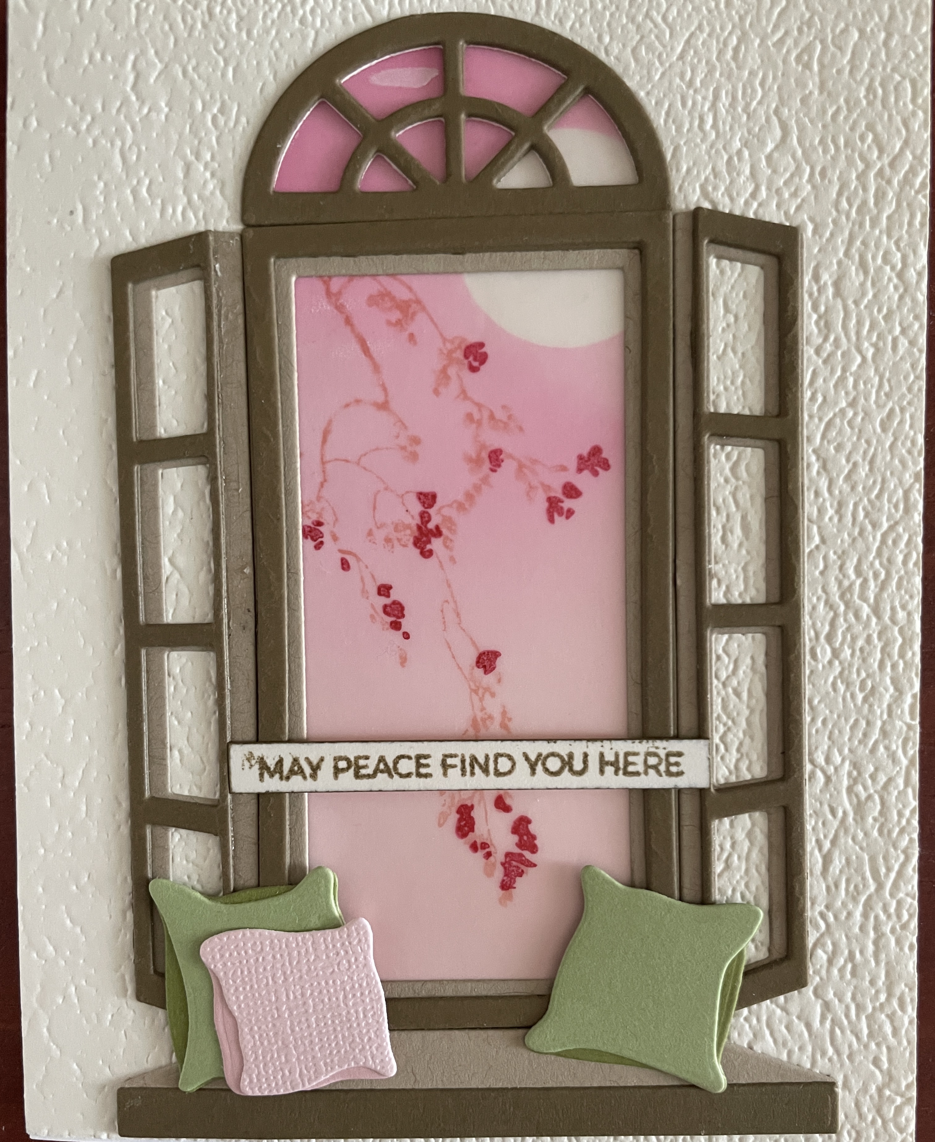 card showing open window with ledge and pillows